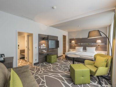 Hotelzimmer mit Doppelbett, Fernseher und Schrank